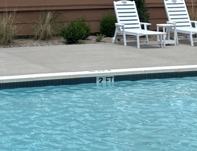 Upgraded Hartstone eased-edge coping and Emser 1x6 waterline tile finish.