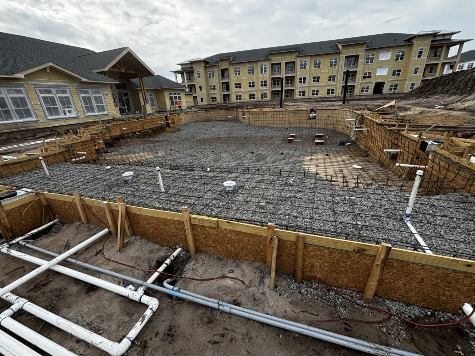 Early construction — rebar, plumbing, and formwork during shell phase.